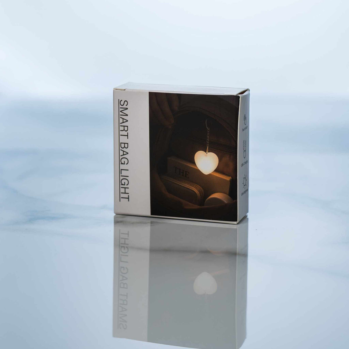 LumiHeart™ Motion Glow heart-shaped motion-activated keychain light in packaging on reflective surface