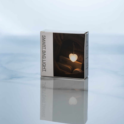 LumiHeart™ Motion Glow heart-shaped motion-activated keychain light in packaging on reflective surface