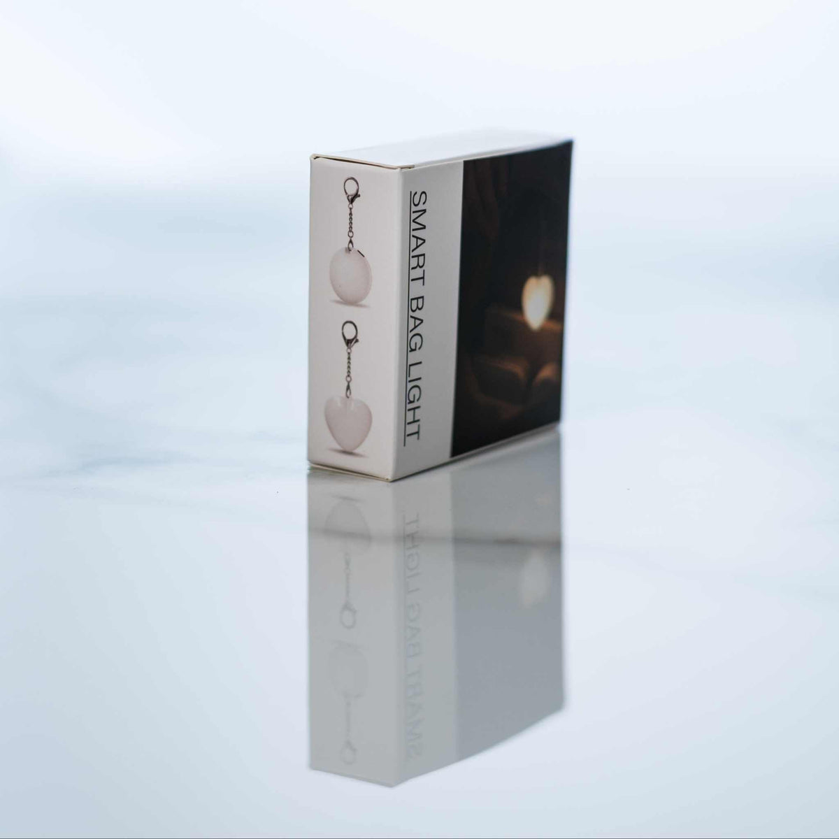 LumiHeart™ Motion Glow keychain light packaging showing heart-shaped motion-activated soft white LED light with metal hook.